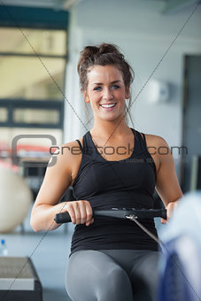 Cheerful woman training on row machine