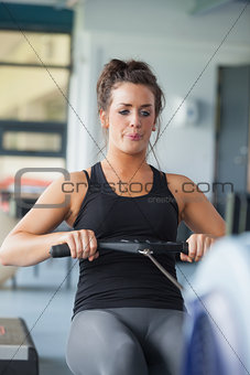 Woman training hard on row machine