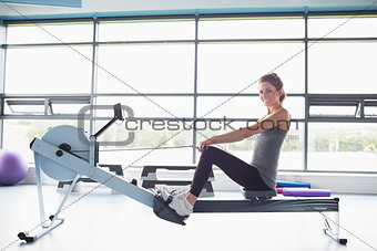 Happy woman training on row machine