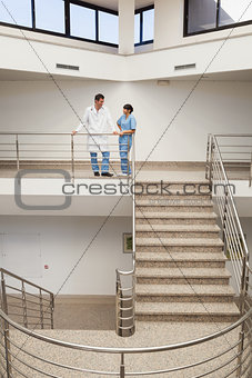 Nurse and doctor talking at top of stairwell