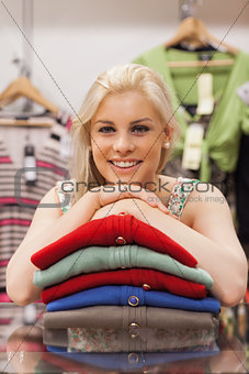 Woman is leaning on clothes and smiling
