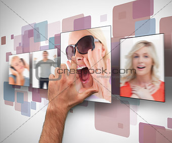 Male hand selecting one photo from digital wall
