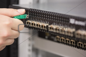 Woman plugging USB cable into server