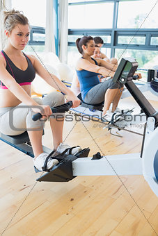 Man and women using the row machines