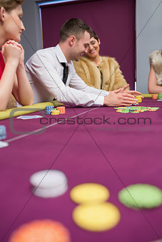 Happy people placing bets at poker game