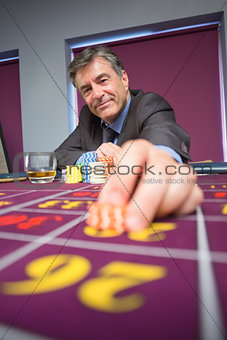 Man sitting and smiling while placing a bet