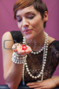 Dice being blown on by woman for luck