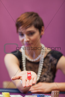 Woman at table holding dices