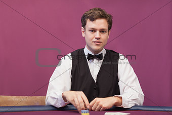 Dealer sitting in a casino distributing chips