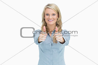 Blonde woman cheerfully doing thumbs up