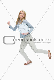 Woman running while holding a clock