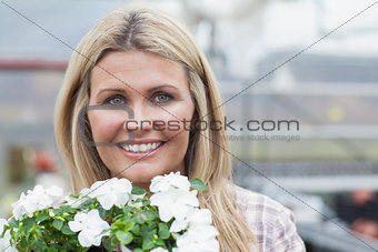 Smiling blonde holding white flowers