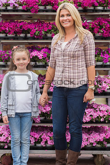 Mother and daughter holding hands in garden center
