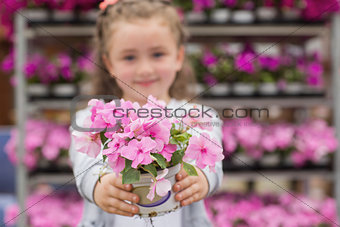 Little girl with flowers in garden center