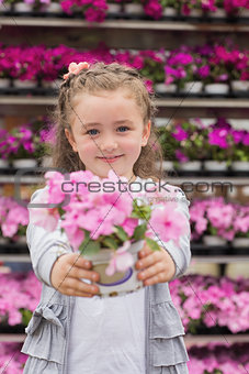 Little girl smiling and holding a flower pot
