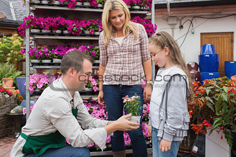 Garden center worker giving a flower to child