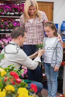 Little girl getting a present from garden center worker