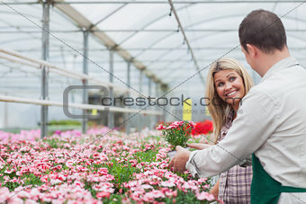Woman choosing flower while talking to florist