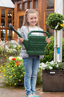 Little girl holding watering can while smiling