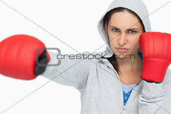 Stern woman in sweatshirt boxing
