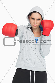 Brunette in sweatshirt boxing with red gloves