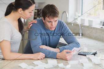 Couple calculating bills in kitchen