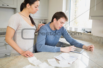 Couple using tablet pc to calculate finances