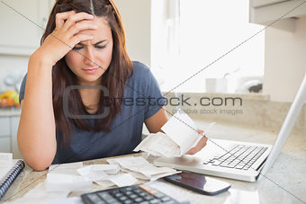 Brunette looking worried over bills