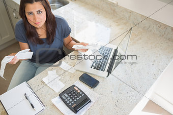 Young woman calculating bills and looking worried