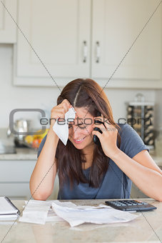 Woman holding a bill to her head