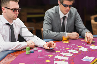 Men sitting at the table wearing sun glasses