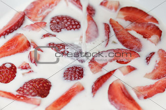 flowing milk splashes on sliced strawberry