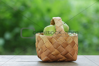green apples in a birchbark basket