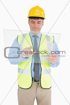 Man in vest and with helmet holding pane