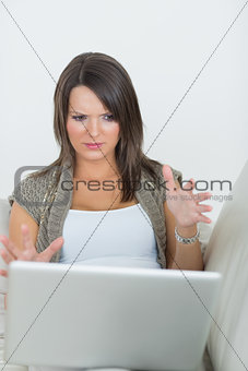 Woman looking wary of laptop