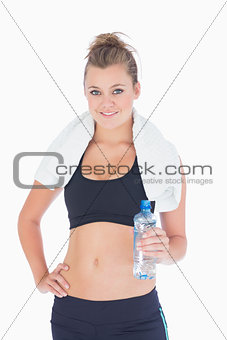 Woman standing hand on hips with bottled water