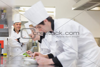 Chef supervising others making salads