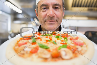 Chef showing a pizza