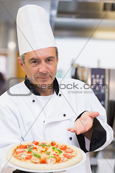 Proud chef showing his pizza