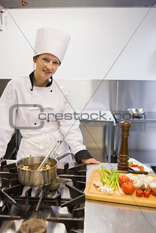 Woman smiling while cooking soup
