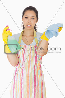 Overworked woman holding rag and spray bottle