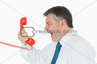 Angry businessman yelling at phone