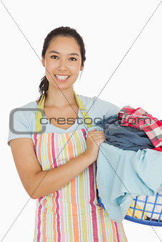 Smiling woman holding laundry basket