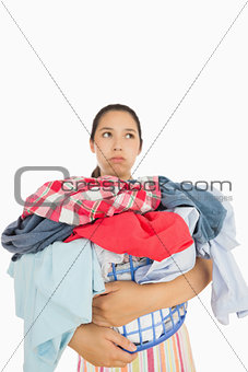 Overworked woman holding basket full of laundry