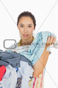 Tired woman holding dirty laundry