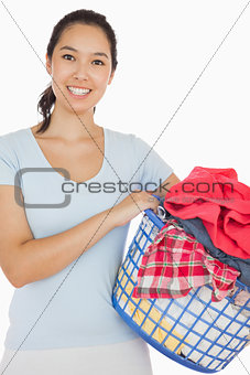 Smiling woman holding a basket full of laundry