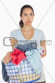 Exasperated woman holding a basket full of laundry