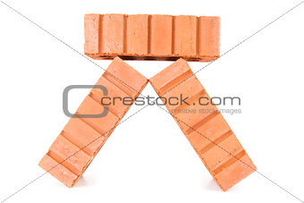 Three clay bricks being piled
