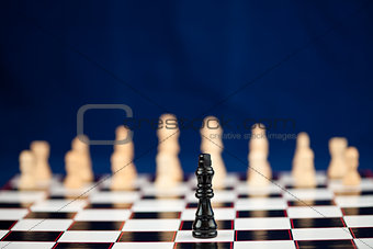Black chess piece standing at the chessboard