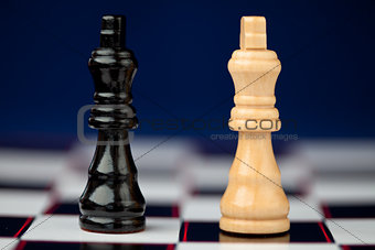 Chess pieces standing at the chessboard beside